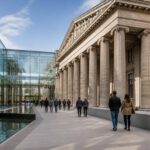 Ingresso di museo con struttura vetrata contemporanea collegata a un portico storico e percorso senza gradini